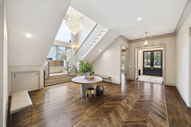 entryway with ornamental molding, plenty of natural light, dark parquet floors, and a chandelier