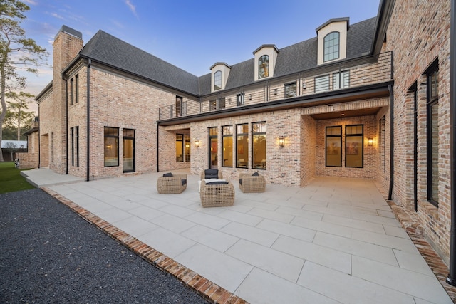 back house at dusk with a patio