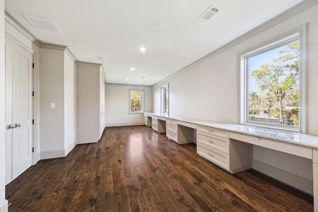 unfurnished office featuring ornamental molding, dark wood-type flooring, and built in desk