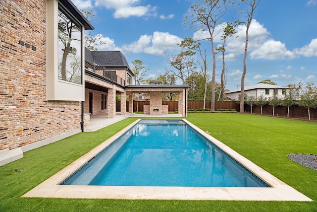 view of pool featuring a yard, a fireplace, and a patio