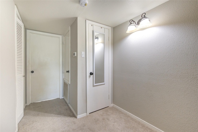 corridor featuring light colored carpet