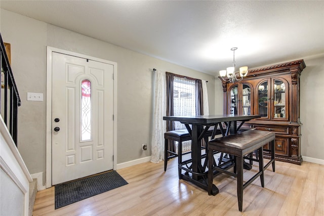 dining room with light hardwood / wood-style flooring and an inviting chandelier