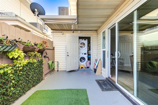 view of exterior entry with a patio area and stacked washer / drying machine