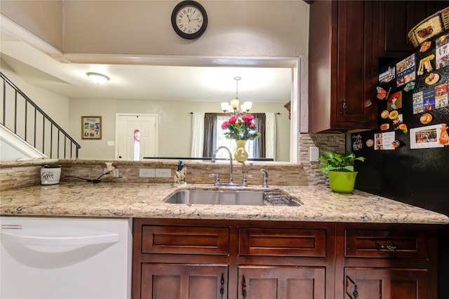 kitchen with light stone countertops, sink, backsplash, a chandelier, and white dishwasher