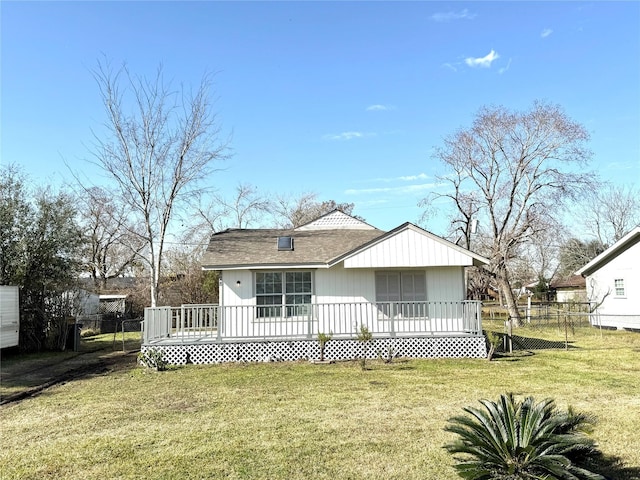 back of house with a deck and a yard