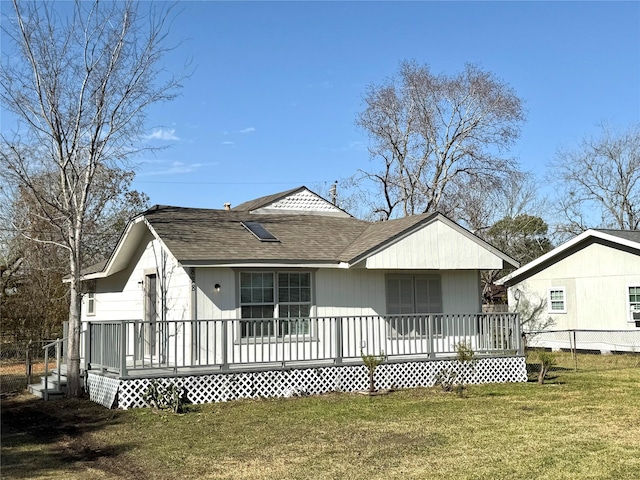 rear view of property with covered porch and a yard