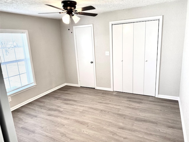 unfurnished bedroom with ceiling fan, a textured ceiling, and light hardwood / wood-style flooring