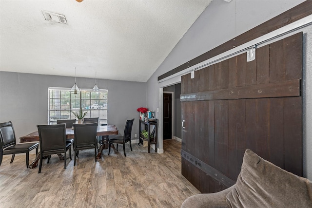 dining room featuring lofted ceiling and wood-type flooring