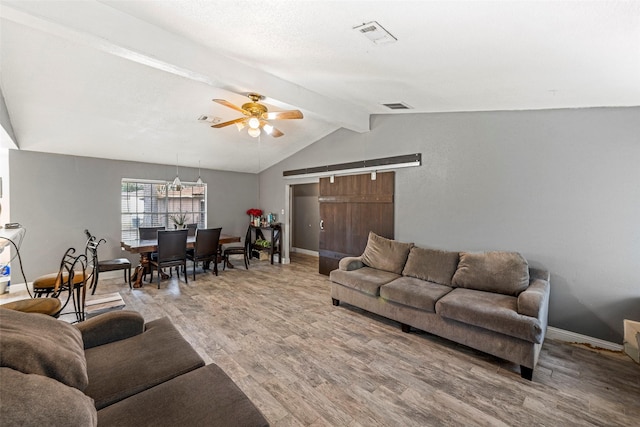 living room with hardwood / wood-style flooring, ceiling fan, and vaulted ceiling with beams