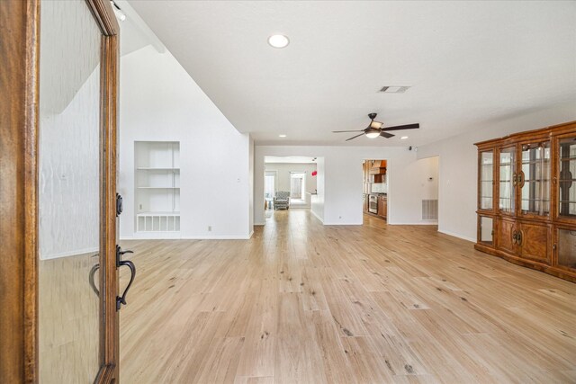 unfurnished living room with ceiling fan, light hardwood / wood-style floors, and built in features