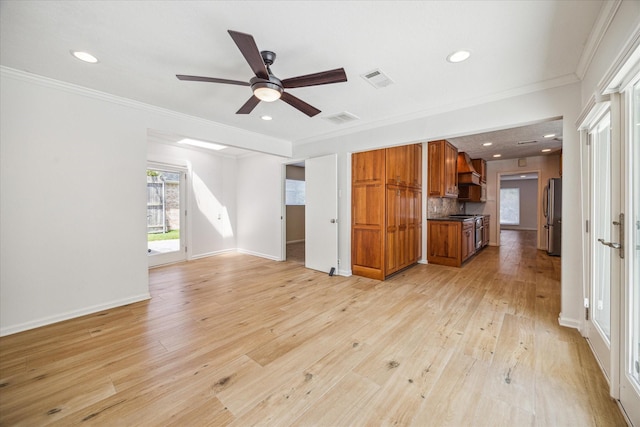 unfurnished living room featuring ceiling fan, crown molding, and light wood-type flooring