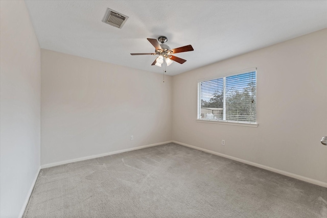 empty room with ceiling fan and light carpet