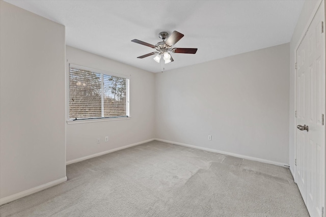 carpeted spare room featuring ceiling fan