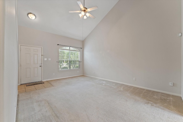 carpeted empty room with ceiling fan and high vaulted ceiling