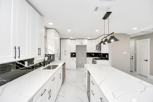 kitchen featuring light stone countertops, sink, pendant lighting, and stainless steel appliances