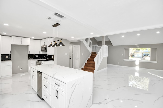 kitchen featuring white cabinets, a center island, decorative backsplash, hanging light fixtures, and light stone counters