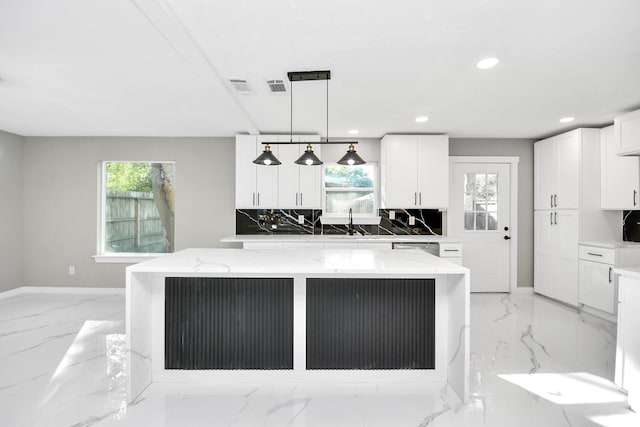 kitchen featuring a kitchen island, white cabinetry, decorative backsplash, hanging light fixtures, and light stone counters