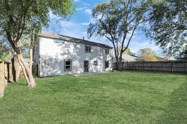 rear view of property featuring a yard and a patio