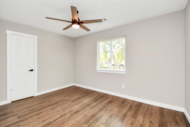 empty room featuring ceiling fan and hardwood / wood-style floors