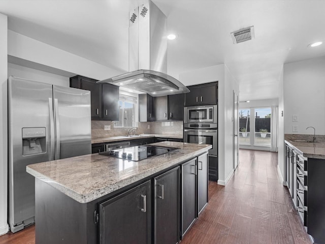 kitchen with appliances with stainless steel finishes, a kitchen island, sink, backsplash, and island range hood