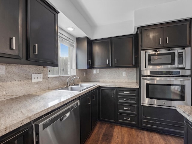 kitchen with stainless steel appliances, backsplash, dark hardwood / wood-style flooring, and sink