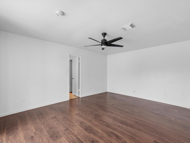 empty room with ceiling fan and dark hardwood / wood-style flooring