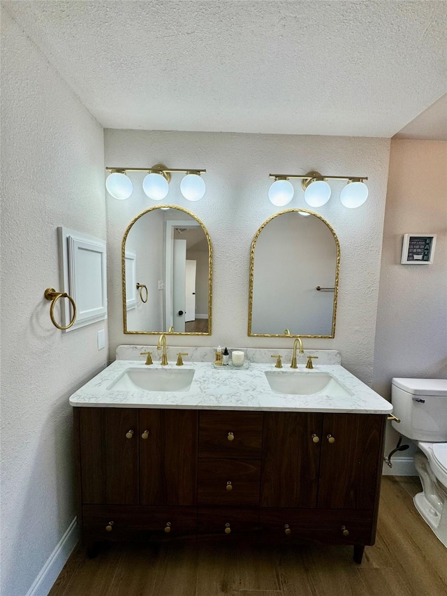 bathroom featuring a textured ceiling, toilet, and wood-type flooring