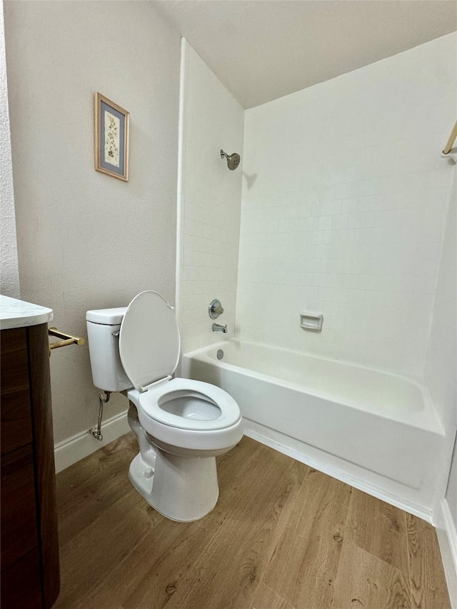 full bathroom with wood-type flooring, toilet, vanity, and tiled shower / bath