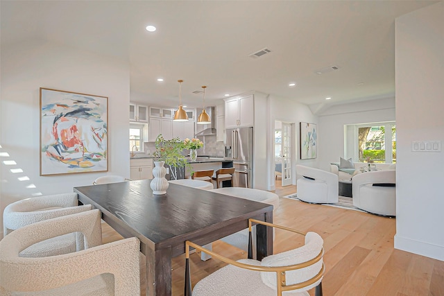 dining space with light wood-type flooring and sink