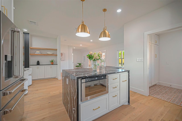 kitchen with pendant lighting, white cabinets, a kitchen island, light hardwood / wood-style flooring, and high end refrigerator