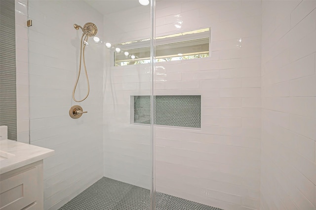 bathroom with vanity and tiled shower