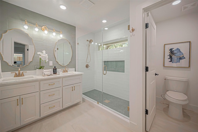 bathroom with a shower with shower door, vanity, tile patterned flooring, and toilet