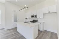 kitchen featuring white cabinetry, a kitchen island with sink, and stainless steel appliances