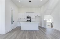 kitchen featuring light hardwood / wood-style flooring, white cabinets, and a center island