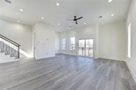 unfurnished living room featuring ceiling fan and hardwood / wood-style floors