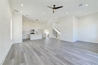 unfurnished living room with ceiling fan and hardwood / wood-style flooring