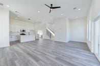 unfurnished living room featuring ceiling fan and wood-type flooring