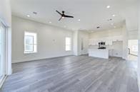 unfurnished living room with ceiling fan, plenty of natural light, and dark hardwood / wood-style floors