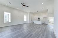 unfurnished living room with ceiling fan and dark wood-type flooring