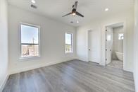 unfurnished bedroom with ceiling fan, multiple windows, and light hardwood / wood-style floors