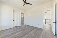 unfurnished room with ceiling fan and dark hardwood / wood-style flooring