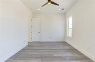 spare room with dark wood-type flooring and ceiling fan