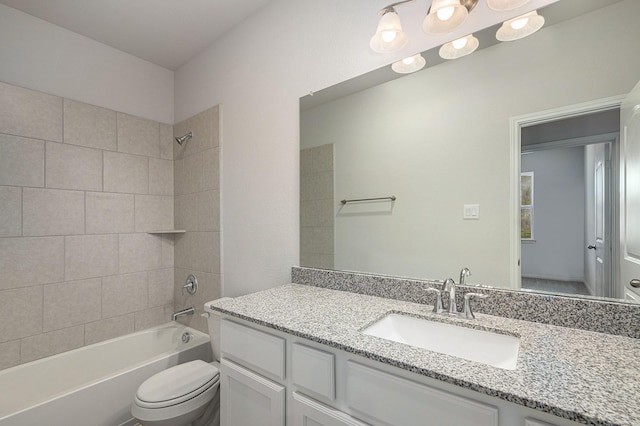 full bathroom featuring toilet, tiled shower / bath combo, and vanity