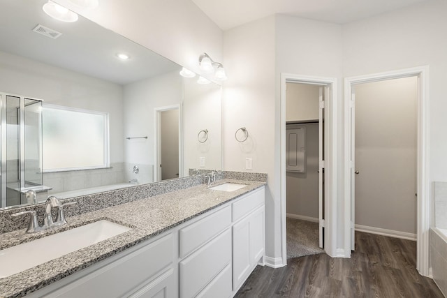 bathroom with wood-type flooring, vanity, and independent shower and bath