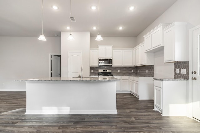 kitchen with white cabinetry, appliances with stainless steel finishes, and an island with sink