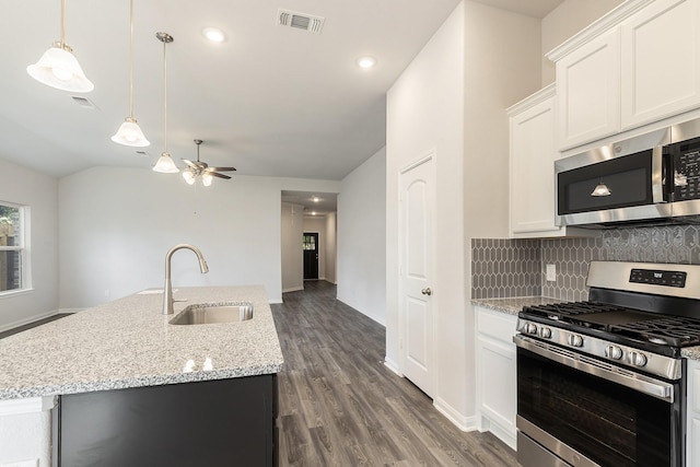 kitchen with white cabinets, a kitchen island with sink, sink, and stainless steel appliances