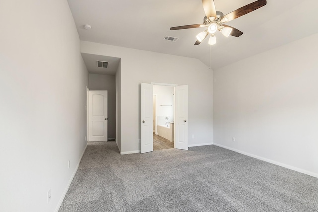 unfurnished bedroom featuring ceiling fan, ensuite bath, vaulted ceiling, and carpet flooring