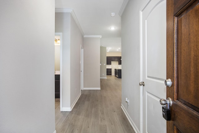 hall with light hardwood / wood-style flooring and crown molding