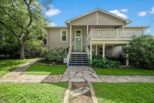 view of front of house with a front lawn and a balcony