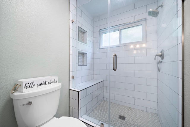 bathroom with toilet and an enclosed shower